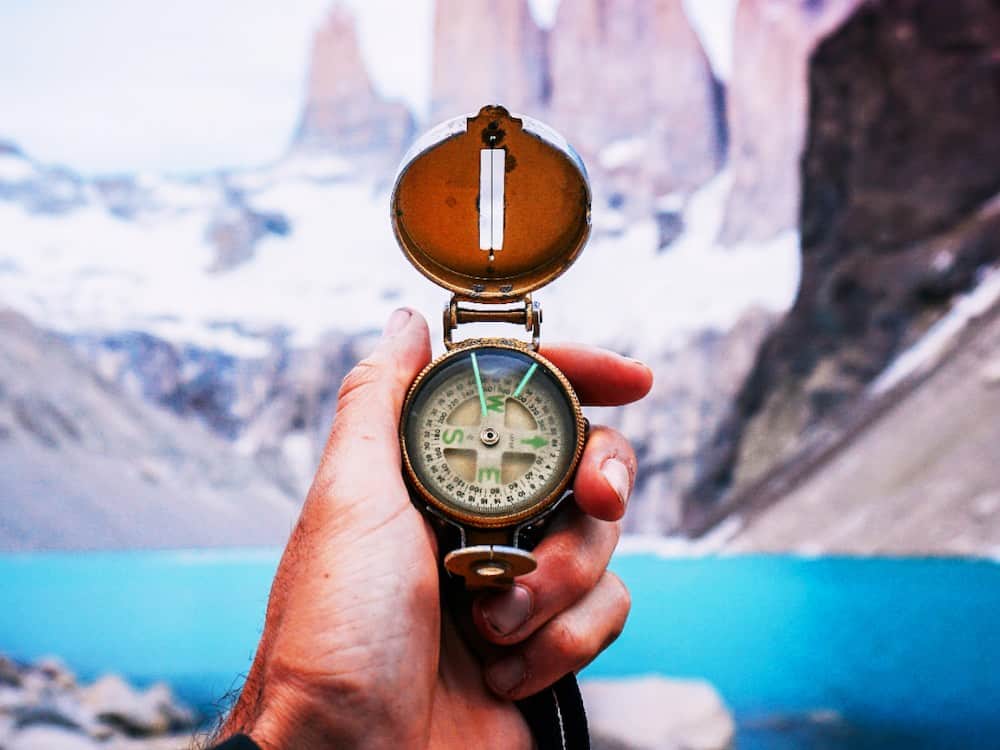 compass in hand snow mountains